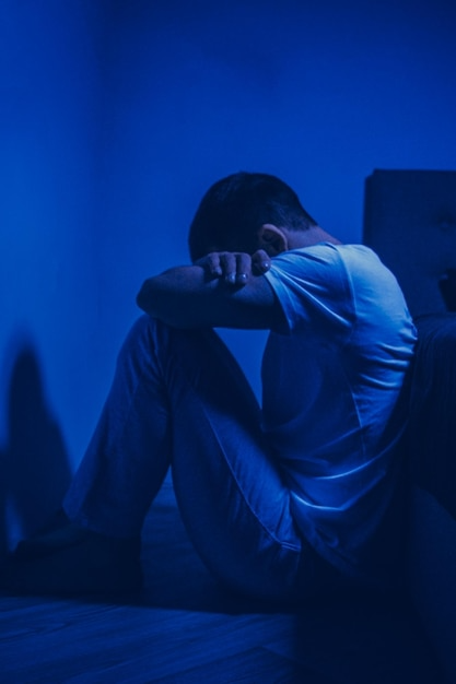 Man sitting alone in blue light (Schizophrenia Services)-Bridge Health (Schizophrenia)