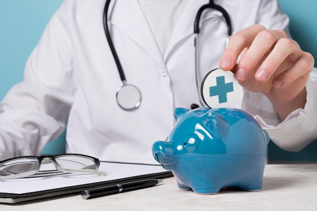 Doctor putting coin in piggy bank-Bridge Health (Insurance)