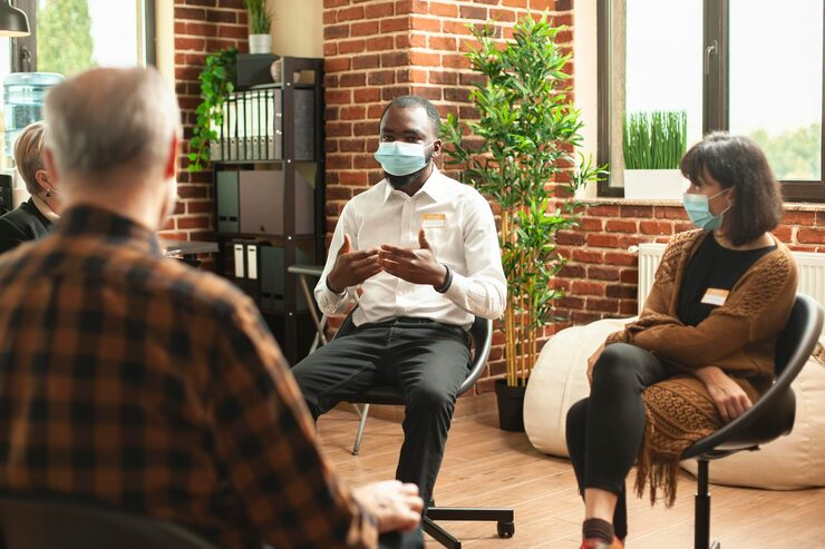 (Group therapy session with masks) PTSD-Bridge Health (about)
